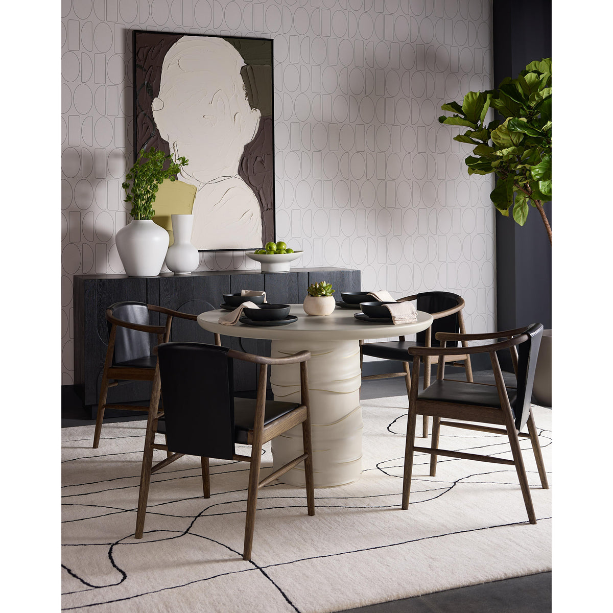 Modern dining room with a round table and chairs, decorative wall art, and plants.