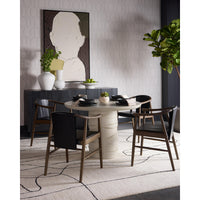 Modern dining room with a round table and chairs, decorative wall art, and plants.