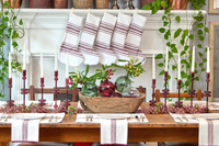 Dining table set for a meal with decorative items and striped table runners.