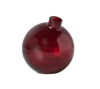 Red glass vase on a white surface with a white background