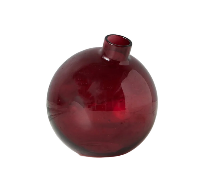 Red glass vase on a white surface with a white background