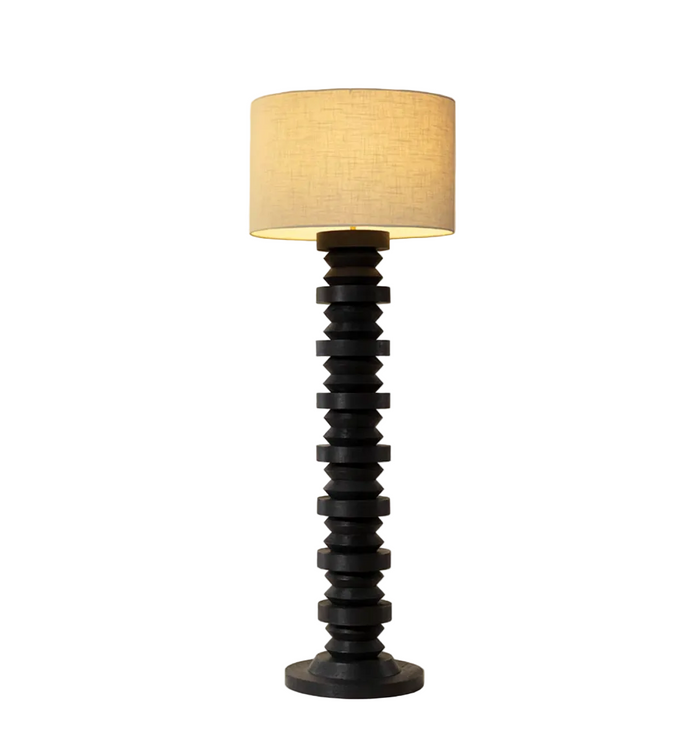 Floor lamp with a black spiral base and beige lampshade on a beige background