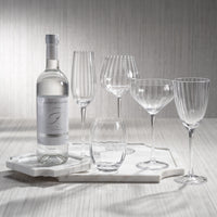 Set of wine glasses and a bottle on a marble tray with a neutral background