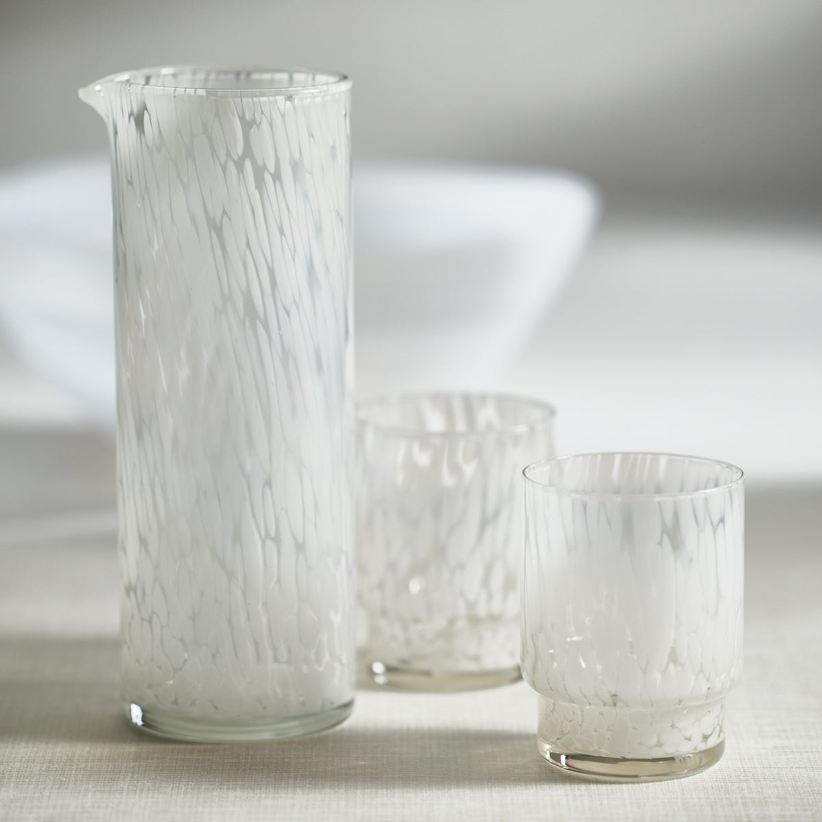 Set of glassware with a white tortoise design on a neutral background