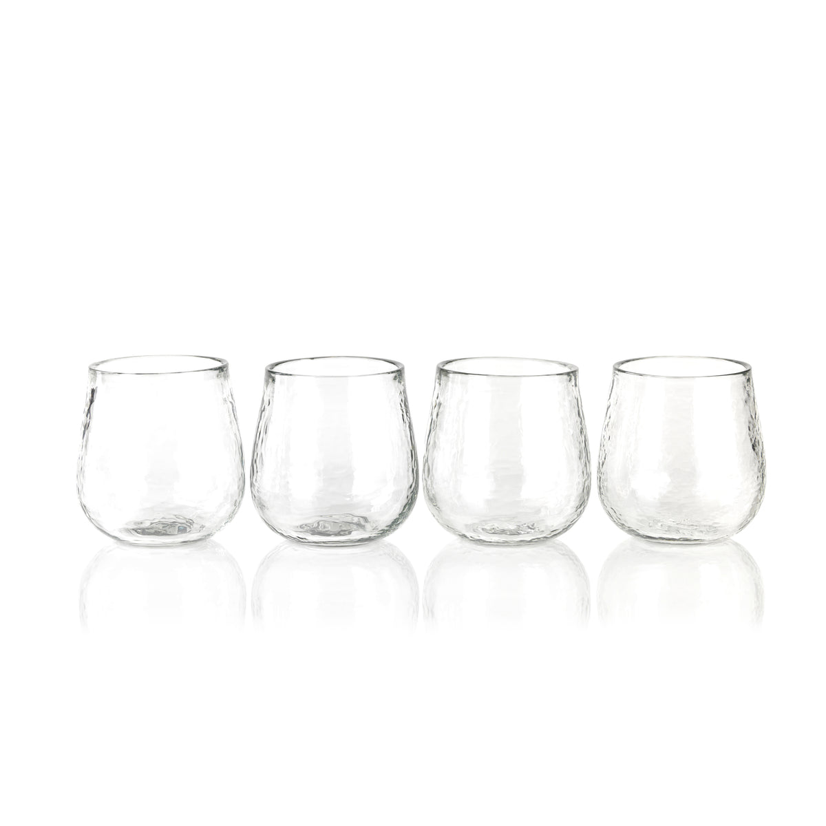 Four clear stemless wine glasses on a white background