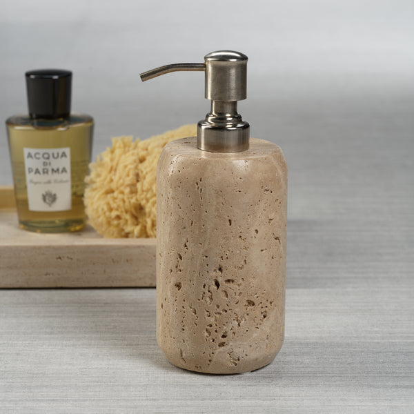Beige stone soap dispenser with silver pump on a neutral background