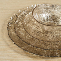 Set of metallic gold plates and bowl on a wooden surface